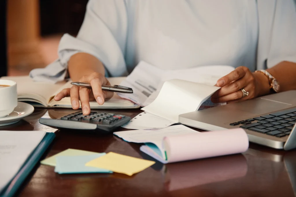 Profissional de contabilidade confere notas e documentos fiscais com a calculadora